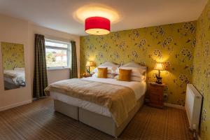 a bedroom with a large bed with yellow walls at Eilean Donan Guest House in Ullapool
