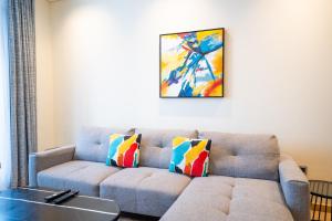 a living room with a couch and a painting on the wall at RH- Modern Comfort, bright 1BR near Dubai Mall, City Views in Dubai