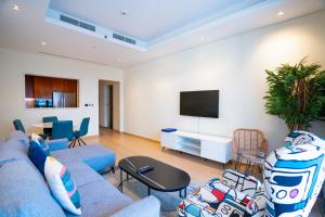 un soggiorno con divano blu e TV di RH- Modern Comfort, bright 1BR near Dubai Mall, City Views a Dubai