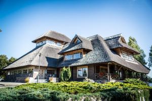 a large house with a thatched roof at Porto Resort in Lilaste