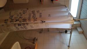 ein Bad mit einem WC und einem Wandschreiben in der Unterkunft Zimmer Frei in Wiesbaden