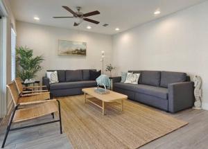una sala de estar con un sofá y una mesa en Beach Retreat Complex w Pool - Sleeps 25, en Jacksonville Beach