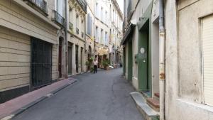 una persona caminando por un callejón entre edificios en Ida Chambres d'hôtes B&B, en Montpellier