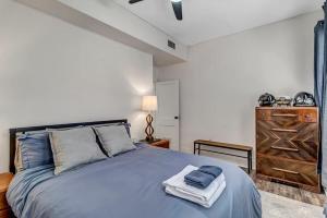 um quarto com uma cama azul e uma cómoda em Contemporary Apartment - 5 Min To TIAA Bank Field! em Jacksonville