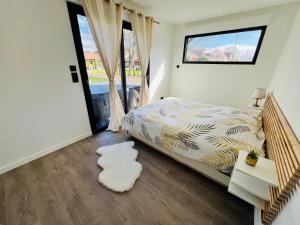 Schlafzimmer mit einem Bett und einem Fenster in der Unterkunft Villa Louméa - Le Loft avec jacuzzi in Friesenheim