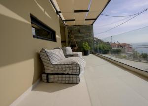 普洛馬里翁的住宿－Irini Design Apartments，两把椅子坐在一个美景阳台