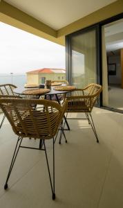 普洛馬里翁的住宿－Irini Design Apartments，一个带桌椅的海景庭院