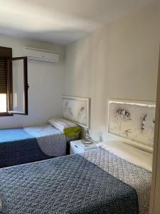 a bedroom with two twin beds and a mirror at Apartamento en Luis Montoto, Nervión. Céntrico in Seville