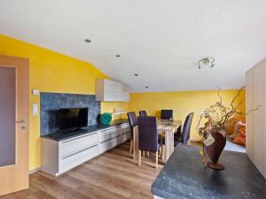 a kitchen and dining room with yellow walls and a table at Sunlit Apartment near Ski Area in Hollersbach im Pinzgau in Hollersbach im Pinzgau
