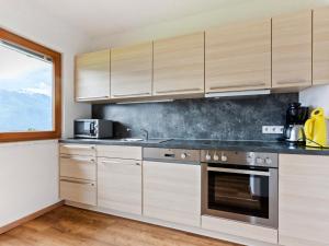 ホラースバッハ・イム・ピンツガウにあるSunlit Apartment near Ski Area in Hollersbach im Pinzgauのキッチン(木製キャビネット、シンク付)