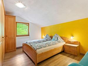 ホラースバッハ・イム・ピンツガウにあるSunlit Apartment near Ski Area in Hollersbach im Pinzgauの黄色の壁のベッドルーム1室