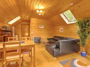 a living room with a leather couch and a table at Detached wooden chalet in Liebenfels Carinthia near the Simonh he ski area in Liebenfels