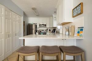 a kitchen with a counter and two stools in it at TIDES BEACH PARADISE best served patch of beach in Jacksonville Beach