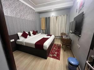 a bedroom with a large bed and a television at Hotel devoy inn by namastexplorer in Rishīkesh