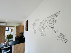 eine Zeichnung einer Weltkarte an einer Wand in einer Küche in der Unterkunft Villa Louméa - Le Loft avec jacuzzi in Friesenheim