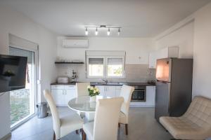 a kitchen with a table and chairs and a refrigerator at Villa Luca Christo in Mrzenci