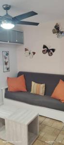 um quarto com um sofá com borboletas na parede em Zoraida del MaryReviva Canarias em El Pris