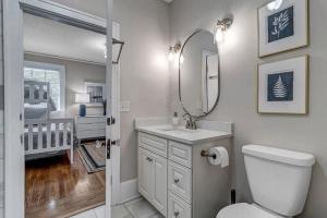 a bathroom with a toilet and a sink with a mirror at Stunning and Cozy 4BR in Historic Avondale in Jacksonville +41 photos