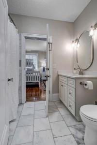 a bathroom with a sink and a toilet and a mirror at Stunning and Cozy 4BR in Historic Avondale in Jacksonville