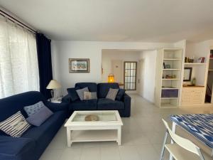 - un salon avec un canapé bleu et une table dans l'établissement ALBATROS 48 by SOM Menorca, à Son Parc