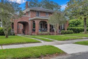 a red brick house with an archway in a yard at Stunning and Cozy 4BR in Historic Avondale in Jacksonville