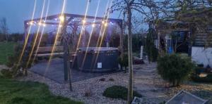 a drum under a gazebo with lights on it at Tęczowy Domek - Balia z hydromasażem in Darłowo +1 photo