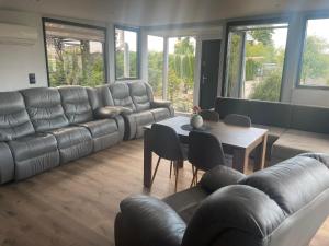 un salon avec un canapé en cuir et une table dans l'établissement Tęczowy Domek - Balia z hydromasażem, à Darłowo