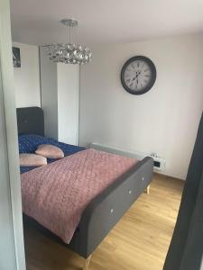 une chambre avec un lit et une horloge murale dans l'établissement Tęczowy Domek - Balia z hydromasażem, à Darłowo