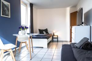 a living room with a couch and a table at CosyHomes24 - Apartment with balcony and parking space - WIT01 in Witten