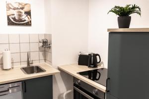 a small kitchen with a sink and a refrigerator at CosyHomes24 - Apartment with balcony and parking space - WIT01 in Witten +5 photos