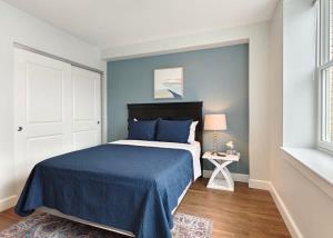 a bedroom with a bed with blue sheets and a window at Fun Cozy Apts - 1 25 Mile Walk to TIAA Bnk Fld in Jacksonville