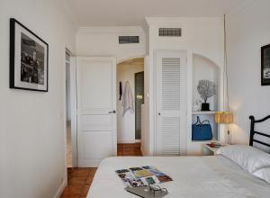 a white bedroom with a bed and a door at Les Bastides 3028 in Grimaud