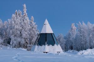 una tienda en la nieve con árboles nevados en Nivunki Village, en Muonio