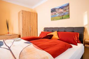 1 dormitorio con 1 cama con almohadas rojas en Gästehaus Bruckner, en Spitz