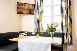 einen Tisch mit zwei Weingläsern und Blumen darauf in der Unterkunft Gästehaus Bruckner in Spitz