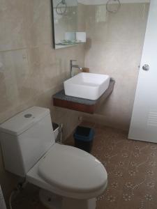 Łazienka z białą toaletą i umywalką w obiekcie Bossert Residence w Panglao City