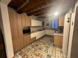 cocina con armarios de madera y suelo de baldosa en Villa Rosa, en Calci