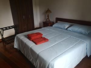 duże łóżko z dwoma czerwonymi ręcznikami w obiekcie Bossert Residence w Panglao City