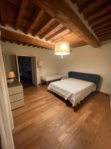 1 dormitorio con 1 cama y suelo de madera en Villa Rosa, en Calci