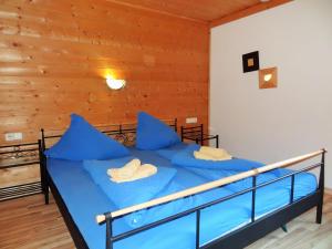 Schlafzimmer mit einem Bett mit blauer Bettwäsche und blauen Kissen in der Unterkunft Cosy holiday home in L ngenfeld in Längenfeld