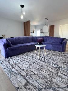 ein Wohnzimmer mit einem blauen Sofa und einem Tisch in der Unterkunft Inizio Apartment in Shkodra