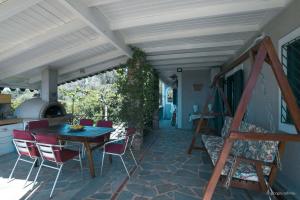 patio con tavolo e sedie di Nerotrivia Villa - Ocean Panorama and Lush Gardens a Nerotriviá