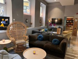 - un salon avec un canapé brun et des fauteuils dans l'établissement Clarion Collection Hotel Borgen, à Örebro