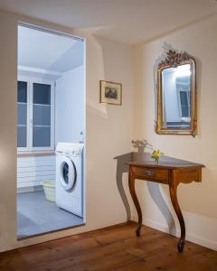 ein Badezimmer mit einer Waschmaschine und einem Spiegel in der Unterkunft Revier z'Uhrmachers in Rüti