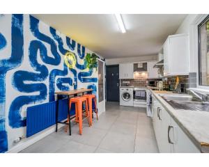 una cocina con una pared azul y blanca en The Wellesley, en Belfast