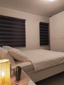a bedroom with a bed and two windows at Saphir Townhouse 5 to 6 pax rooftop terrace, Cavite in Imus