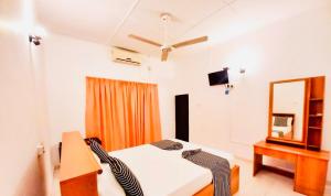 ein Schlafzimmer mit einem Bett, einem Spiegel und einer Kommode in der Unterkunft Sima's Cottage in Anuradhapura