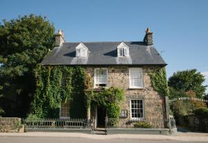 an old stone house with ivy on it at Llys Meddyg in Newport Pembrokeshire