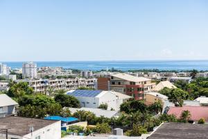 a city with buildings and the ocean in the background at Le studio du voyageur in Saint-Denis