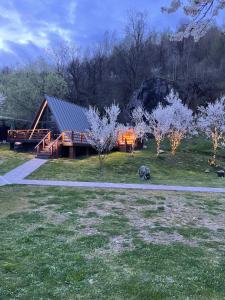 a cabin in the middle of a field with trees at Valea Mosului - Cozy A Frame in Petroşani